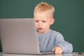 Serious concentrate child using laptop computer, kid boy studying through online e-learning. Little funny system Royalty Free Stock Photo