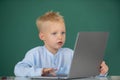 Serious concentrate little school kid boy study in a classroom. Little funny programmer. Royalty Free Stock Photo