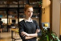 Serious concentrated redhead lady student posing indoors in library