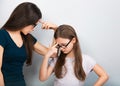 Serious concentrated; thinking mother and kid in glasses on blue background. Closeup studio portrait. Teaching kids staying at