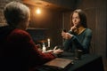 Serious concentrated woman looking at tarot card at soothsayer consultation