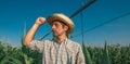 Serious concerned farmer in cornfield with irrigation system