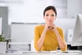 Serious, confident and ambitious business woman sitting at her desk while resting her chin on her hands. Portrait of a