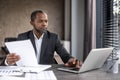 Serious confident businessman financier inside office at workplace checking documents, reports and contracts. Senior man Royalty Free Stock Photo
