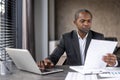 Serious confident businessman financier inside office at workplace checking documents, reports and contracts. Senior man Royalty Free Stock Photo