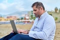 Serious confident mature man with laptop outdoors Royalty Free Stock Photo