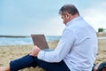 Serious confident mature man with laptop outdoors Royalty Free Stock Photo