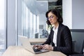 Serious confident thinking businesswoman at work with laptop inside office, female office worker in business suit Royalty Free Stock Photo