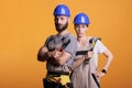 Serious construction workers posing with pair of pliers and hammer Royalty Free Stock Photo