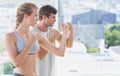 Serious couple standing in boxing stance in fitness studio