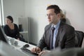 Serious devoted business man work in office on computer. Real economist business people, not models. Bank employees discussing Royalty Free Stock Photo