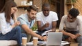 Serious diverse friends study together with laptop notebooks in cafe