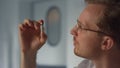 Doctor examining vaccine vial closeup. Physician considering vial with vaccine.