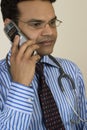 Serious doctor speaking on mobile phone