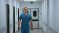 Serious doctor walking down hospital corridor. Medic going in clinic hallway. Royalty Free Stock Photo