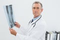 Serious doctor with xray picture of spine in office