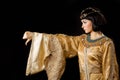 Serious Egyptian woman like Cleopatra with thumbs down gesture, on black background Royalty Free Stock Photo