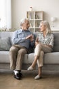 Serious elder grey haired husband and wife talking on couch Royalty Free Stock Photo