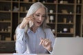 Serious elderly freelance business woman engaged in phone conversation Royalty Free Stock Photo