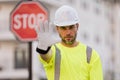 Serious engineer with stop road sign. Builder with stop gesture, no hand, dangerous on building concept. Man in helmet Royalty Free Stock Photo