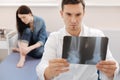 Serious experienced rheumatologist holding an X ray image