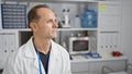 Serious-faced middle age man, a meticulous scientist, sitting immersed in his work, experimenting with test tubes in a bustling