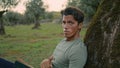 Serious farmer relaxing nature portrait. Calm man posing at olive tree close up