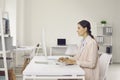 Serious female accountant sitting at office desk and working on desktop computer Royalty Free Stock Photo