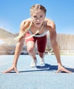 Serious female athlete at the starting line in a track race competition at the stadium. Fit sportswoman mentally and Royalty Free Stock Photo