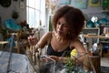 Focused brunette lady creating a florarium at professional studio