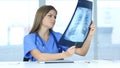 Serious Female Doctor Examing X-ray of Patient, Lungs and Ribcage Royalty Free Stock Photo