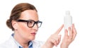 serious female doctor in eyeglasses pointing by finger at pill bottle