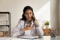 Serious female doctor giving telephone consultation, talking to patient