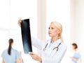 Serious female doctor looking at x-ray Royalty Free Stock Photo