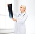 Serious female doctor looking at x-ray Royalty Free Stock Photo