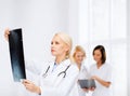 Serious female doctor looking at x-ray Royalty Free Stock Photo