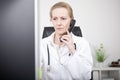Serious Female Doctor on Phone Looking at Monitor Royalty Free Stock Photo