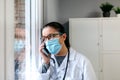 Female doctor talking on the cell phone looking out the window Royalty Free Stock Photo