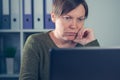 Serious female freelancer working on laptop computer Royalty Free Stock Photo