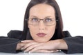 Serious female lawyer wearing suit and glasses, white background, arms on office desk Royalty Free Stock Photo