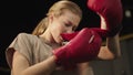 Serious fit girl putting on boxing gloves at gym. Boxer preparing for training Royalty Free Stock Photo