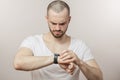 Serious fit, sporty man is looking at the smartwatch