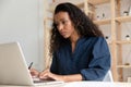 Serious focused African American businesswoman using laptop in office