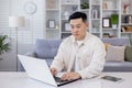 Serious and focused Asian man, businessman, freelancer, student working studying at home using laptop, Sitting at table Royalty Free Stock Photo