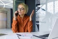 Serious focused business woman talking on the phone, female boss at workplace inside office, using laptop at work Royalty Free Stock Photo