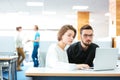 Serious focused man and woman working with laptop in office