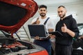 Serious focused men car technician mechanics repairing car problem of engine