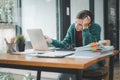 Serious focused woman looking at laptop screen, touching chin, sitting at desk, Royalty Free Stock Photo