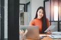 Serious focused woman looking at laptop screen, touching chin, sitting at desk, Royalty Free Stock Photo