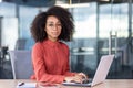 Serious focused woman working inside office with laptop, business woman looking thinking at camera, thoughtful and Royalty Free Stock Photo